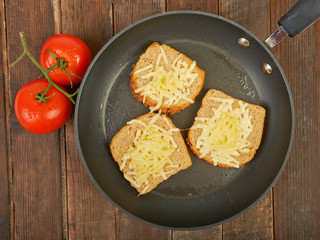 Photo of a grilled cheese sandwich cooking in a large frying pan