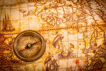 Obraz na płótnie Canvas Vintage compass lies on an ancient world map.