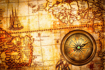 Fototapeta na wymiar Vintage compass lies on an ancient world map.