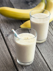 Banana smoothie on dark wooden background