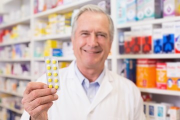 Fototapeta na wymiar Senior pharmacist holding blister packs