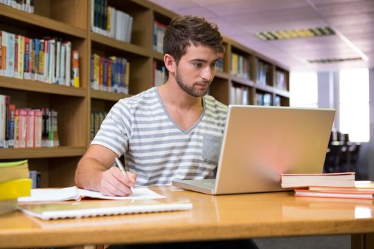 Student studying in the library with laptop