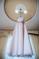 Wedding dress hanging on the chandelier in the room