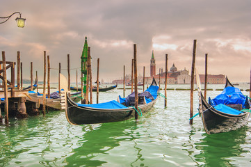 Fototapeta na wymiar Gondolas docked to the poles on the Grand Canal in Venice.