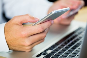 Man using laptop and smartphone
