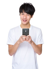 Young asian man texting message at his mobile phone