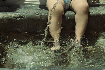 baby with feet in the cool water