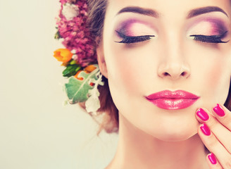 Fototapety  Dziewczyna z delikatnymi kwiatami we włosach i modnymi paznokciami w kolorze fuksji