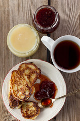 Cup of tea, plate of pancakes, jam, honey