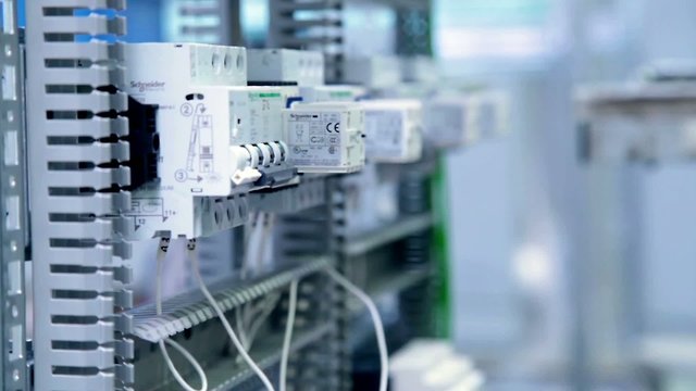 A man is installing an automatic electric circuit breaker