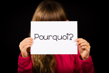 Child holding sign with French word Pourquoi - Why