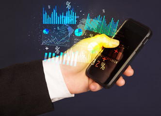 Hand holding smartphone with business diagrams