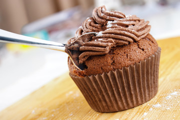 Chocolate cupcake with icing and spoon