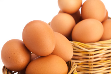 Close-up Eggs in 2 wicker baskets on isolated white background. Shallow focus on front basket.