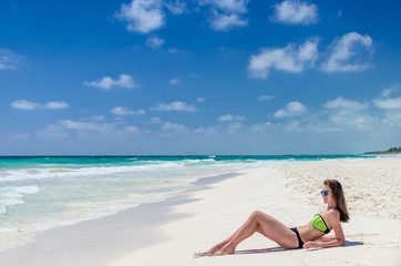Fototapeta na wymiar Young cute woman lying and getting some sun on tropical beach