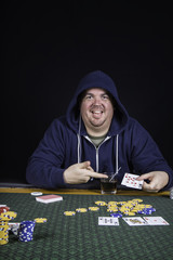 A man playing poker sitting at a table bluffing