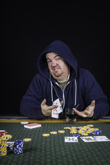 A man playing poker sitting at a table bluffing