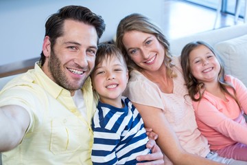 Obraz premium Happy family taking selfie on couch