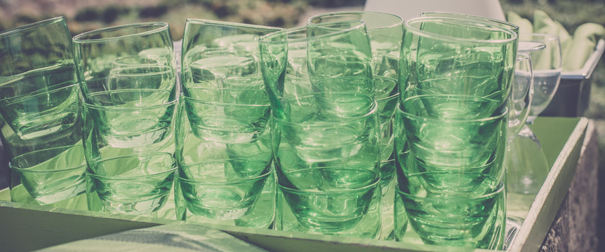 Green clear glasses stacks on the table in a cafe
