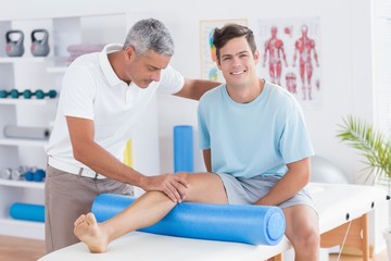 Obraz premium Doctor examining his patient leg