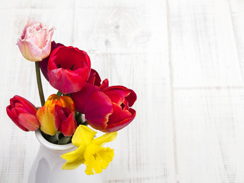 tulips bouquet on white wooden background