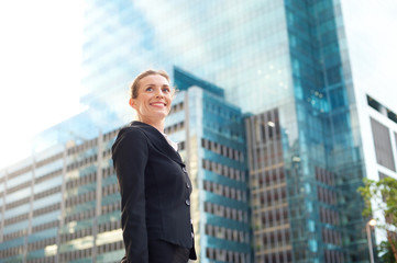 Fototapeta premium Happy business woman walking outside in the city