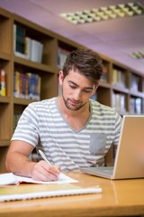 Student studying in the library with laptop