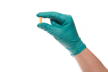 Fototapeta premium Hand with glove holds a pill up