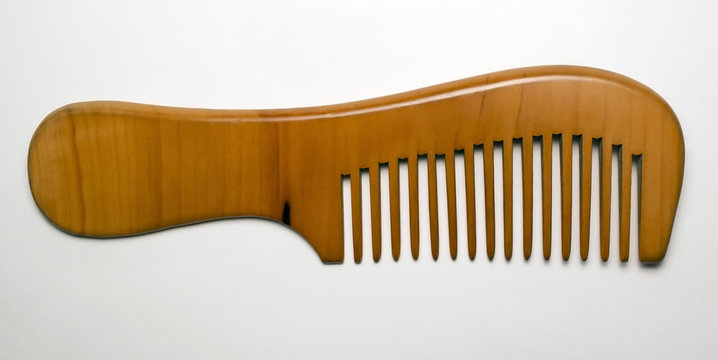 Elegant wooden comb on white background