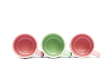 Green and pink ceramic coffee cups on white background