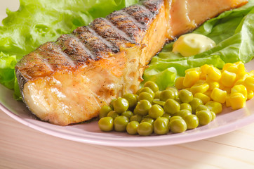 Grilled salmon at dish on wooden background