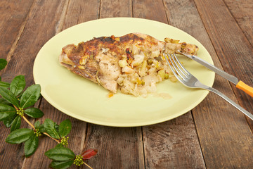 Grilled chicken on the grill on a plate on a wooden table