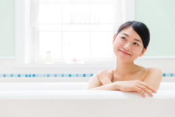young asian woman relaxing in the bathroom