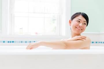 young asian woman relaxing in the bathroom