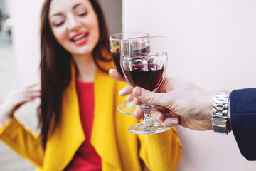 Woman clinking red wine glass with man outdoors