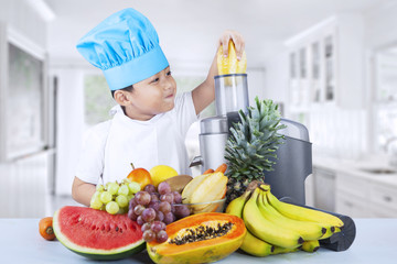 Little boy making fruit juice