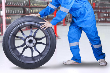 Obraz na płótnie Canvas Technician changing a tire at workshop