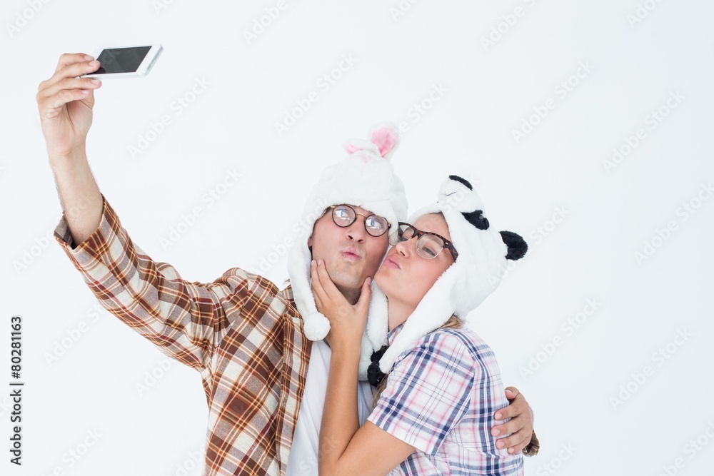 Poster geeky hipster couple taking selfie with smart phone
