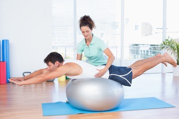 Trainer with man on exercise ball