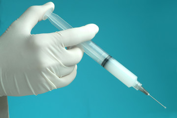hand with protective glove injecting drug with syringe.