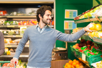 Man picking up vegetables in a grocery store