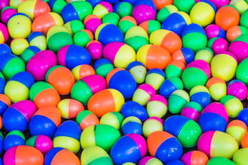 Fototapeta na wymiar Colorful plastic eggs toys floating on the water background