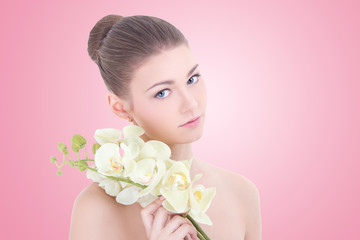 portrait of young beautiful woman with orchid flower over pink