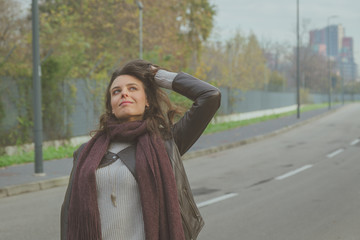 Naklejka premium Beautiful young brunette posing in the city streets