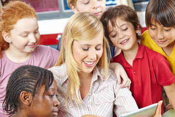 Teacher and students looking at tablet computer