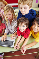 Children in elementary school with laptop