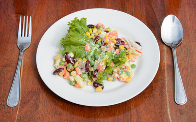 Salad in plate on wood background