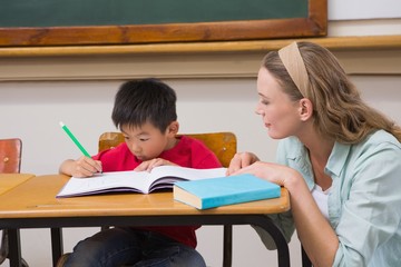 Teacher helping pupil in classroom