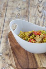 Bowl with curry flavored rice chicken and vegetables