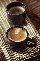 Two cups of espresso coffee on napkin